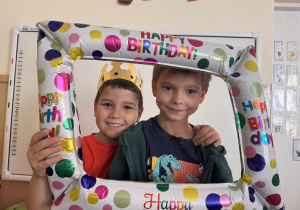 Chłpcy pozują do zdjecia z urodzinową ramką.